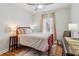 Comfortable bedroom with a red frame bed, hardwood floors, and a window with neutral curtains at 2465 Main St # 201, Atlanta, GA 30344