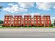 Apartment building with multiple units, manicured landscaping, and a bright blue sky at 2465 Main St # 201, Atlanta, GA 30344