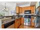 Well-lit kitchen featuring stainless steel appliances, granite countertops, and wood cabinets at 2465 Main St # 201, Atlanta, GA 30344