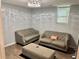 Finished basement area with a comfortable gray sofas and stylish ottoman on wood-look floors at 403 Hickory Walk, Woodstock, GA 30188