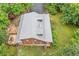 An aerial view showcases the log cabin home with its metal roof and surrounding lush green trees at 521 East Valley Ne Rd, Rydal, GA 30171