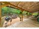 Expansive covered wooden deck with outdoor seating, barbecue grill and wooded views at 521 East Valley Ne Rd, Rydal, GA 30171
