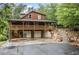 Exterior of log home featuring a two-car garage, covered porch and landscaped driveway entrance at 521 East Valley Ne Rd, Rydal, GA 30171