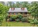 Exterior of log cabin home surrounded by lush greenery featuring dormer windows at 521 East Valley Ne Rd, Rydal, GA 30171