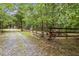 Rustic home exterior with gravel driveway, fenced pasture, and mature trees at 521 East Valley Ne Rd, Rydal, GA 30171