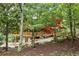 Exterior shot of home with a wooden deck and garage beneath, all nestled amongst mature trees at 521 East Valley Ne Rd, Rydal, GA 30171