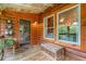 Inviting porch with log siding, natural wood flooring, and charming decor with views to the outdoors at 521 East Valley Ne Rd, Rydal, GA 30171