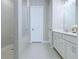 Bright bathroom features tiled shower with glass door, vanity with white cabinets and light countertops at 992 Harvest Park Ln, Suwanee, GA 30024