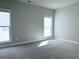 Empty bedroom with neutral carpet, paint, windows with blinds, and white trim at 992 Harvest Park Ln, Suwanee, GA 30024