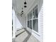 Inviting front porch with brick flooring, white columns, and modern hanging lantern lights at 992 Harvest Park Ln, Suwanee, GA 30024