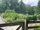 Wooden fence and gate lead to a community garden with herbs, vegetables, and flowers at 992 Harvest Park Ln, Suwanee, GA 30024