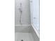 Close up of updated tiled shower with showerhead, bench and frameless glass door at 992 Harvest Park Ln, Suwanee, GA 30024
