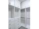 Walk-in closet features custom shelving, drawers, hanging rods and gray carpet at 992 Harvest Park Ln, Suwanee, GA 30024