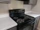 A close-up of a black stove with four burners and gray cabinets in the kitchen at 2566 Stratford Ln, Morrow, GA 30260