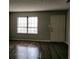 Well-lit living room with a window, a door, and wood-look laminate flooring at 2566 Stratford Ln, Morrow, GA 30260