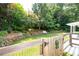 Beautiful backyard featuring a lush lawn, stone wall, and white bench seating at 2915 Preakness Nw Dr, Marietta, GA 30064