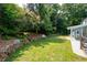 Beautiful backyard featuring a lush lawn, stone wall, and white bench seating at 2915 Preakness Nw Dr, Marietta, GA 30064