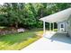 Wide backyard with lawn, stone wall, white bench, and covered patio at 2915 Preakness Nw Dr, Marietta, GA 30064