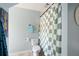 Bright bathroom featuring toilet and a green checkered shower curtain at 2915 Preakness Nw Dr, Marietta, GA 30064
