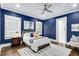 Stylish main bedroom with a tray ceiling, dark blue walls, hardwood floors, and an ensuite bathroom at 327 6Th Ne St, Atlanta, GA 30308