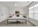 Neutral bedroom featuring a ceiling fan, bright window, and minimalist decor at 833 Society Ct, Woodstock, GA 30188