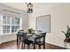 Formal dining area with a black table set, hardwood floors, and natural light at 833 Society Ct, Woodstock, GA 30188
