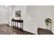 Hallway with hardwood floors, traditional table, lamp, and stairs to the upper level at 833 Society Ct, Woodstock, GA 30188
