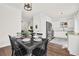 Well-lit eat-in kitchen boasts white cabinets, stainless appliances, and a dining table with seating at 833 Society Ct, Woodstock, GA 30188