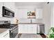 Modern kitchen with stainless steel appliances, white cabinets, and a subway tile backsplash at 833 Society Ct, Woodstock, GA 30188