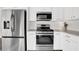 Well-equipped kitchen with stainless steel appliances and white cabinets, including a refrigerator and gas range at 833 Society Ct, Woodstock, GA 30188