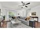 Comfortable living room with hardwood floors and large windows, featuring a stylish gray sectional sofa at 833 Society Ct, Woodstock, GA 30188