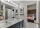 Bright bathroom with double sinks, stylish flooring, and elegant fixtures; view to bedroom at 992 Harbins Pass Dr, Dacula, GA 30019