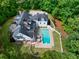 Aerial view of backyard oasis with pool, green lawn, and surrounding mature trees at 5588 Rhododendron Trl, Douglasville, GA 30135