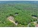 A distant aerial view of the home site amid lush, green forest at 5588 Rhododendron Trl, Douglasville, GA 30135