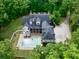 A high aerial view of home with a pool surrounded by vibrant green trees at 5588 Rhododendron Trl, Douglasville, GA 30135