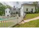 A backyard featuring a pool, patio, and lush lawn with white picket fencing at 5588 Rhododendron Trl, Douglasville, GA 30135