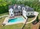 Aerial view of a sparkling pool, a lounging area, and a white picket fence at 5588 Rhododendron Trl, Douglasville, GA 30135