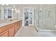 Bright bathroom featuring double vanity and glass shower with pebble floor at 5588 Rhododendron Trl, Douglasville, GA 30135