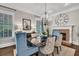 Dining room featuring a fireplace, chandelier, and light blue chairs at 5588 Rhododendron Trl, Douglasville, GA 30135