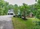 Exterior side view of a well-manicured lawn with a charming home nestled among mature trees at 5588 Rhododendron Trl, Douglasville, GA 30135