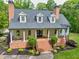 Stunning home with a welcoming brick porch, elegant white columns, and beautiful landscaping surrounded by lush greenery at 5588 Rhododendron Trl, Douglasville, GA 30135