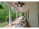 Spacious covered porch featuring elegant columns, comfortable seating, and serene views of the surrounding greenery at 5588 Rhododendron Trl, Douglasville, GA 30135