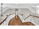 An open hallway features wood floors and white railing with wood trim, offering great light from the chandelier above at 5588 Rhododendron Trl, Douglasville, GA 30135