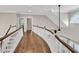 Upstairs hallway with stained hardwood floors and white railing and posts at 5588 Rhododendron Trl, Douglasville, GA 30135
