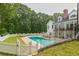 An in-ground backyard pool area featuring a white picket fence and a large grassy lawn at 5588 Rhododendron Trl, Douglasville, GA 30135
