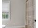 The shower is spacious with a window allowing natural light, a patterned shower curtain, and neutral walls at 5588 Rhododendron Trl, Douglasville, GA 30135