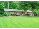 Beautifully landscaped brick home with a lush green lawn and mature trees in a serene setting at 2884 Bent Creek Nw Dr, Kennesaw, GA 30152