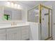 Bright bathroom vanity next to shower with gold frame and fixtures at 2910 Leeds Garden Ln, Alpharetta, GA 30022