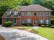 Beautiful brick home featuring a well-maintained lawn, colorful shutters, and a welcoming entrance at 2910 Leeds Garden Ln, Alpharetta, GA 30022