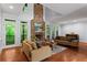 Bright living room with a stone fireplace, hardwood floors, and scenic outdoor views at 2910 Leeds Garden Ln, Alpharetta, GA 30022